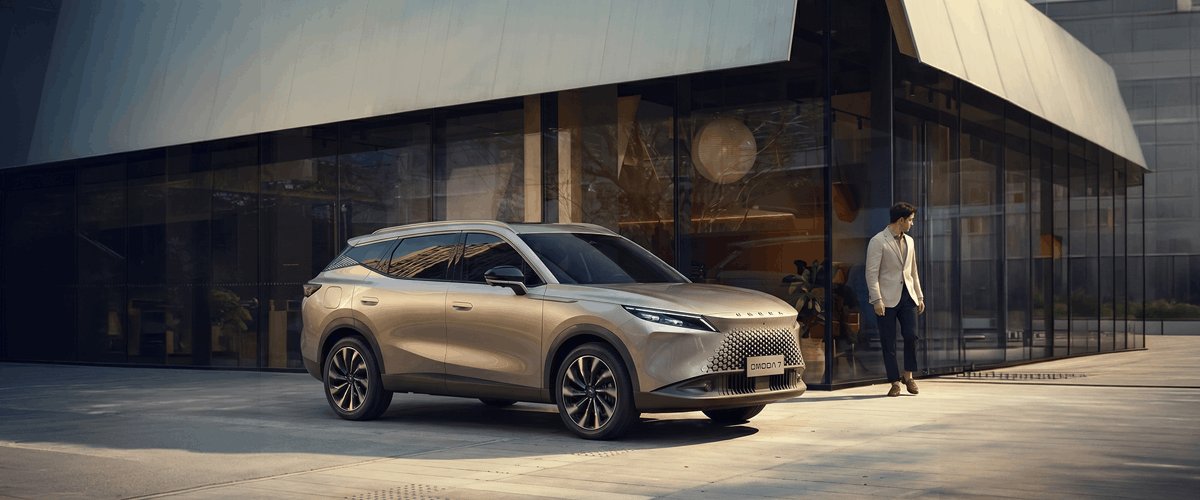 Modern cam mimarili bir binanın önünde park halinde duran premium tasarımlı yeni OMODA 7 SUV modeli